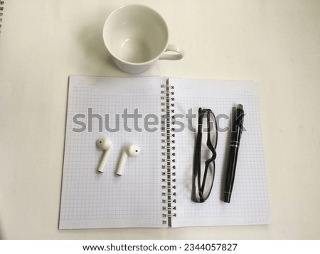 A notebook with a pen and glasses on it.