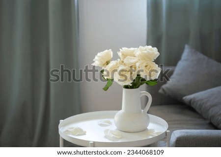 bouquet of white roses in white jug in modern interior