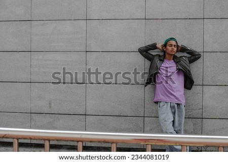 relaxed urban young man on street wall Royalty-Free Stock Photo #2344081019