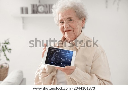 Senior woman with smart home security system control panel, closeup Royalty-Free Stock Photo #2344101873