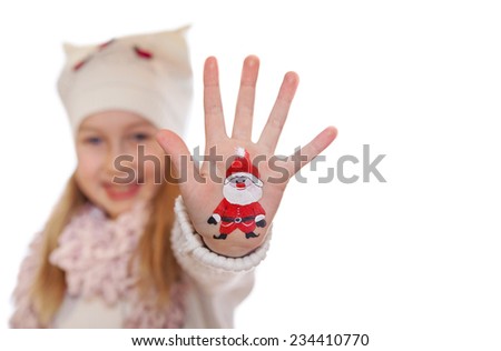 Happy girl demonstrating painted Christmas symbols on her hands. Santa Claus 