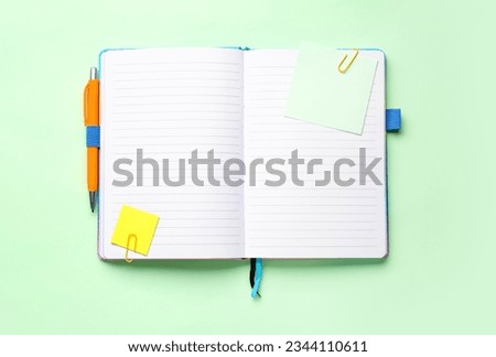 Sticky notes and notepad on green background