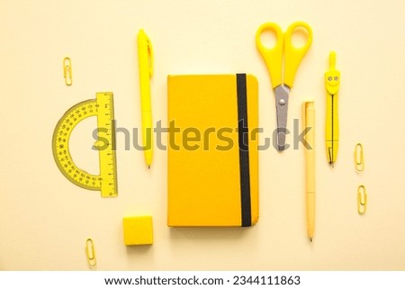 Different school stationery and notebook on beige background