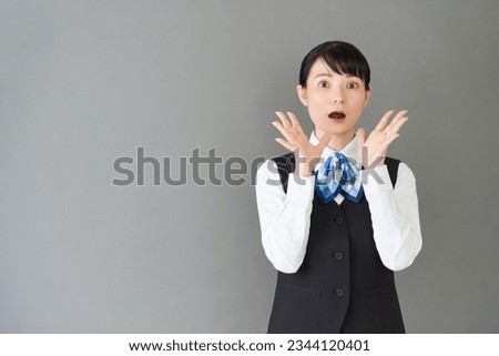 Receptionist and clerical women in uniforms with vests and ribbon ties