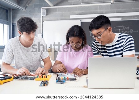 Group of teenage multiethnic students work as a team in technology class with computer and electronic systems Royalty-Free Stock Photo #2344124585