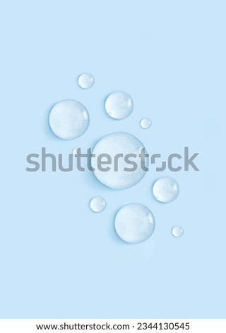 drop of serum gel cosmetic essence on a blue background Royalty-Free Stock Photo #2344130545