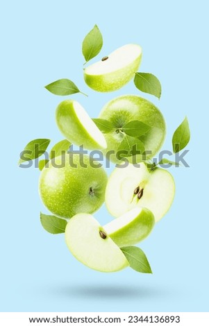 Juicy green apples with green leaves closeup levitation as swirl on light blue background, whole, half, quarter fruit, isolated, shadow. Summer fruits for advertising, design, label product.