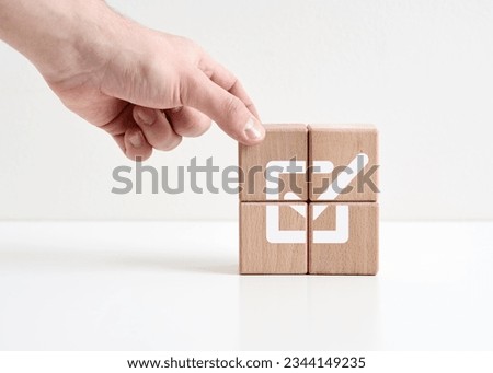 Goal achievement and business success. Task completion. Getting the job done. Agree and approval. Hand places wooden cubes with checkmark symbol.