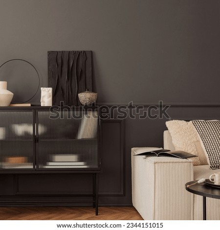 Creative composition of living room interior with mock up poster frame, glass sideboard, vase with dried flowers, modular sofa, wooden floor, dark wall and personal accessories. Home decor. Template.