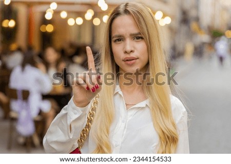 Displeased upset young woman reacting to unpleasant awful idea, dissatisfied with bad quality, wave hand, shake head No, dismiss idea, dont like proposal outdoors. Teenager girl walking in city street Royalty-Free Stock Photo #2344154533
