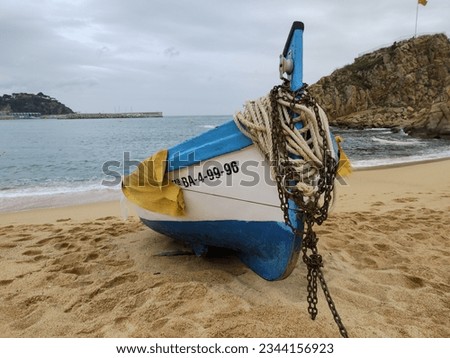 Detail of a small fishing boat moored on the beach on a cloudy day