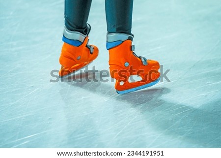 Close-up of a girl's legs in fashion skates on an outdoor ice rink, a young girl skating thinking on the open rink