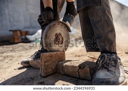 Close up of builder cutting bricks at construction site. Building a house concept.