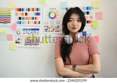 Confident Asian female designer standing with arms crossed and looking at camera. Creative occupation concept