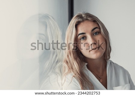 Positive serious millennial model girl home female head shot portrait. Beautiful young adult Caucasian woman looking at camera, posing in apartment. Front profile picture