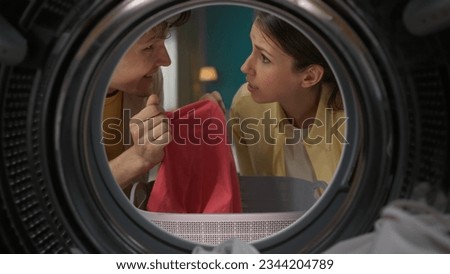 View from inside the washing machine, young couple talking looking at each other while doing laundry Royalty-Free Stock Photo #2344204789