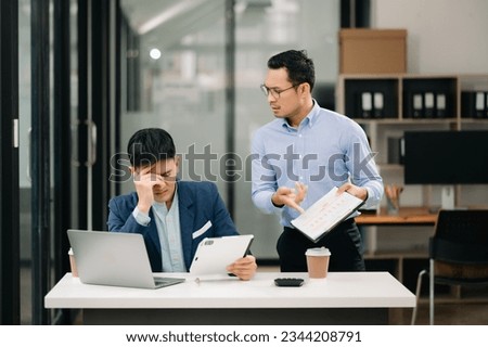 Furious two Asian businesspeople arguing strongly after making a mistake at work in modern office Royalty-Free Stock Photo #2344208791