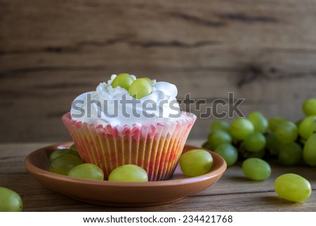 sweet cupcakes with cream and grapes