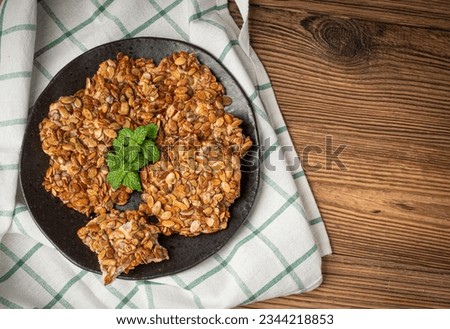 Pumpkin Seeds Cookies on Black Plate, Pepita Grains Biscuit, Healthy Cereal Crackers, Homemade Pumpkin Seed Cookie Group on Rustic Wooden Table Background Top View