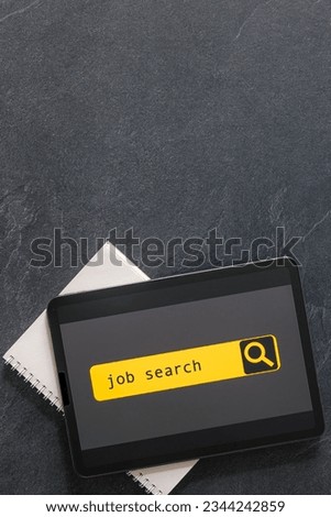 Top view of digital tablet with search job on screen.