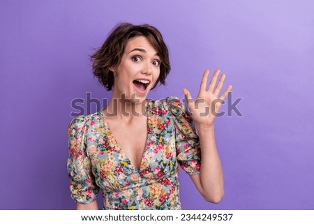 Photo portrait of attractive young woman waving hand hello greeting wear trendy flower print clothes isolated on violet color background