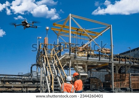 drone operator with remote control for a thermal UAV camera, surveying a construction site, in an industrial area, drone inspection young mining engineer and control technician at a diamond mine Royalty-Free Stock Photo #2344260401