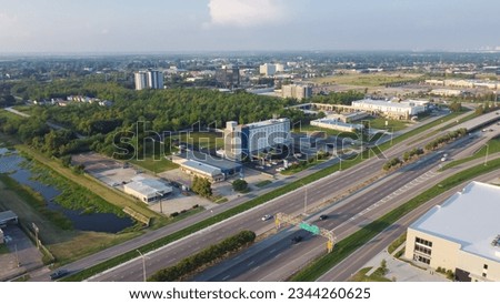 Office buildings, multi-story hotels, business park, car rental, restaurants along Interstate Highway 10 (I-10) in downtown Little Woods, urban neighborhoods New Orleans, Louisiana, USA. Aerial view