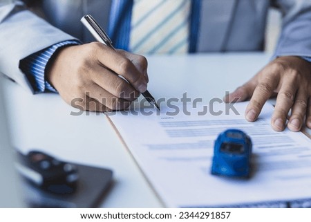 Businessman signing car purchase, lease contract agreement with car salesman, car insurance. Royalty-Free Stock Photo #2344291857