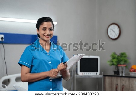 Happy Smiling Nurse with Clipboard standing confidently by looking camera at hospital - Concept of professional occupation, Medical Profession and Career Success