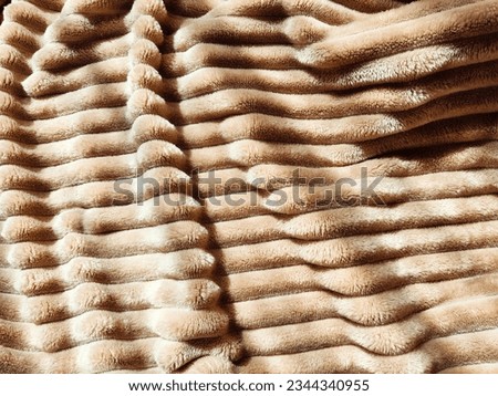 Closeup soft, fluffy sleeping beige blanket or plaid. Crumpled fabric. Abstract background, texture with frame. Partial focus