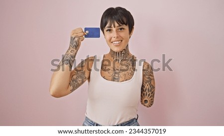 Hispanic woman with amputee arm smiling confident holding credit card over isolated pink background