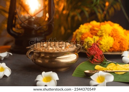 Temple Payasam Ari payasam or sarkara payasam in a golden uruli with flowers on the background, Onam sadhya special food Royalty-Free Stock Photo #2344370549
