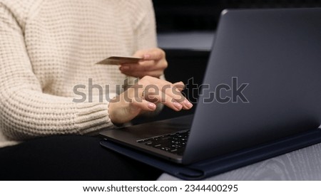 Close-up of a beautiful European girl taking a credit card to fill out card information Sitting online shopping through a laptop to use a credit card to pay online.