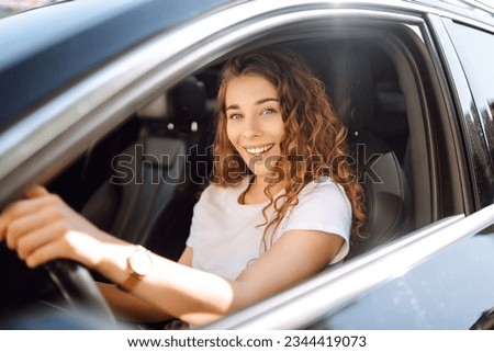 Stylish woman driving a car. The traveler is the driver. Automobile travel. Sharing a car. Lifestyle concept.