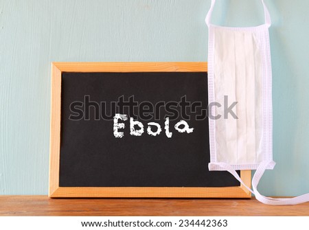blackboard with the word ebola written on it and face mask