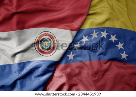 big waving realistic national colorful flag of paraguay and national flag of venezuela . macro
