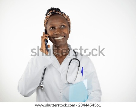 Young female doctor talking on the phone while smiling. Isolated on white background
