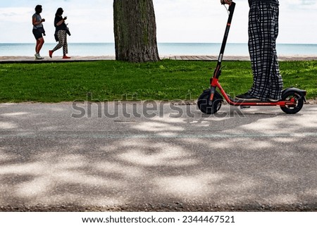 Person going by on scooter in beaches area Toronto Canada 