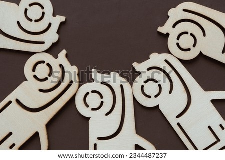 laser cut plywood holiday ornaments (trucks) arranged in a part radial pattern on blank brown paper