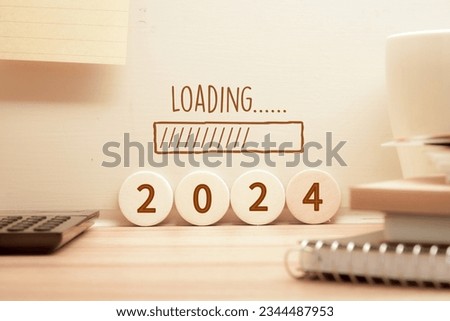 2024 loading inscription on wooden blocks and wall on study desk. New year start concept.