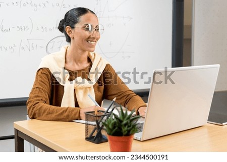 Hispanic Latin girl college student using laptop computer watching distance online learning seminar class, remote university webinar or having virtual classroom meeting in university creative space.