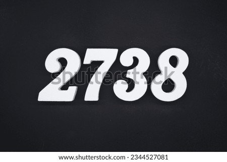 Black for the background. The number 2738 is made of white painted wood. Royalty-Free Stock Photo #2344527081