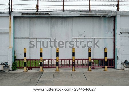 A red and yellow barrier protect on the parking area at the entrance warehouse, stock photo.