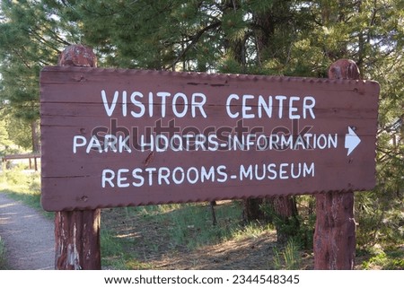 Brown and white park sign for visitor center, park headquarters, information, restrooms and museum