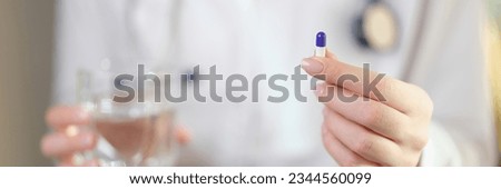 Female doctor holds one medical pill in her hand close-up. Pharmacist reminds about correct dose for taking medicine. Royalty-Free Stock Photo #2344560099