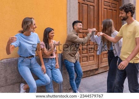 Group of multiracial friends waving in the city, friendship concept with guys and girls hanging out in the city street