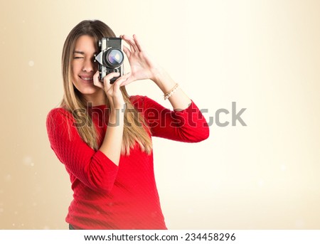 Girl taking a picture over ocher background 
