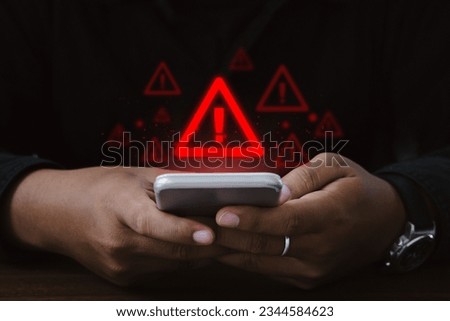 Man using smartphone with warning sign.Notification error and virus detection spyware, Internet network security concept.Computer related crime act.