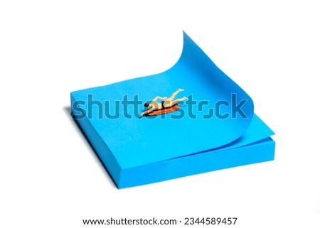 Creative miniature people toy figure photography. Sticky notes installation. A men surfer swimming above surfing board. Isolated on white background. Image photo