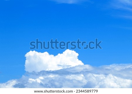 Background with clear contrast between bright blue summer sky and white clouds.
